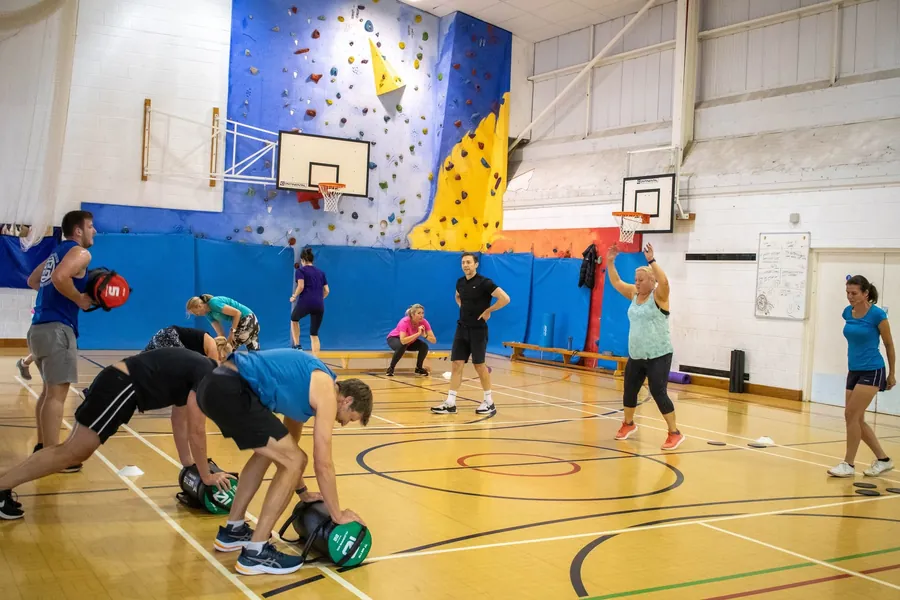 A group class working with medicine balls in the sports hall